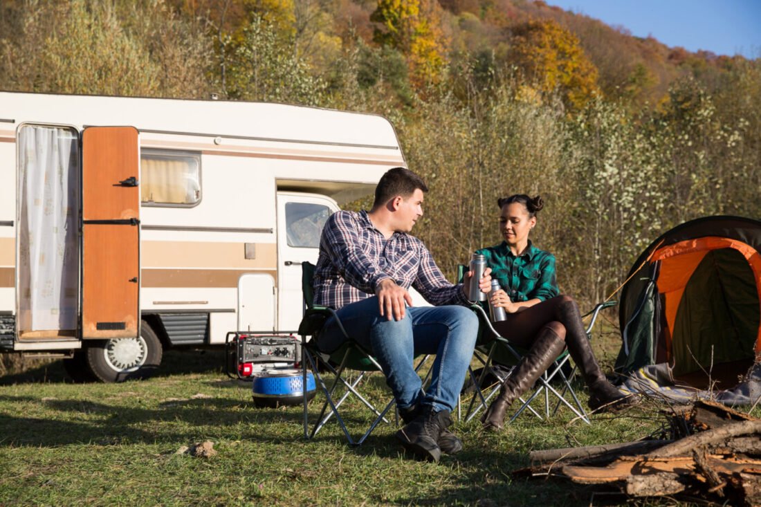 couple enjoying their time camping with a camping generator
