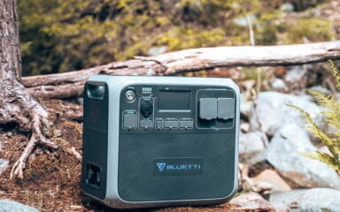 A portable power station on a dirt hill in the middle of a forest.