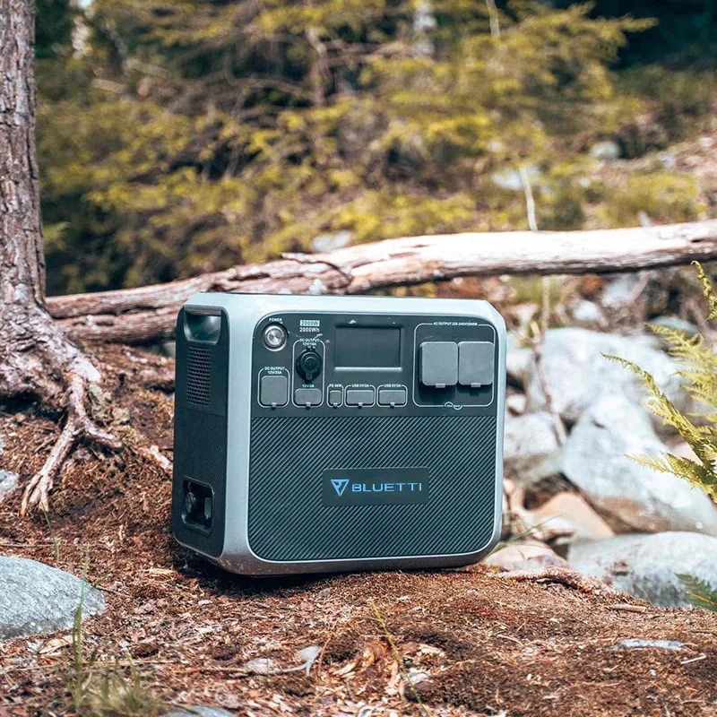 A portable power station on a dirt hill in the middle of a forest.